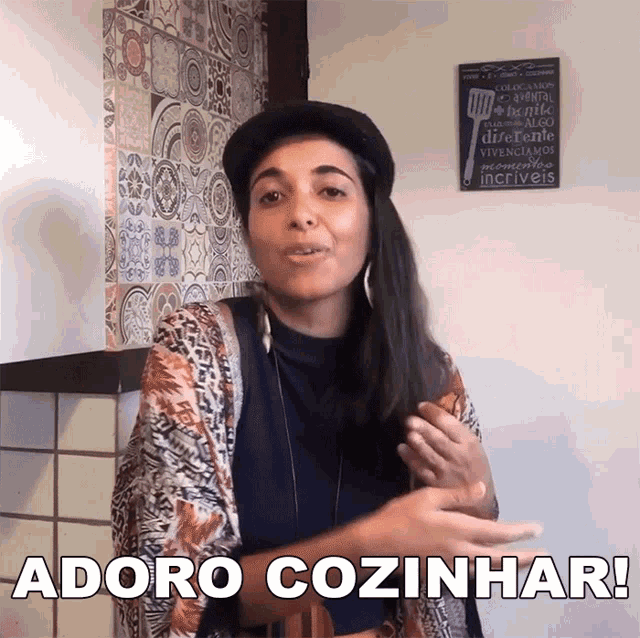 a woman says adoro cozinhar while standing in front of a tiled wall