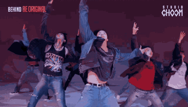 a group of young men are dancing in front of a sign that says studio choom