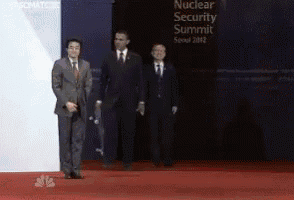 three men in suits are standing in front of a sign that says nuclear security summit