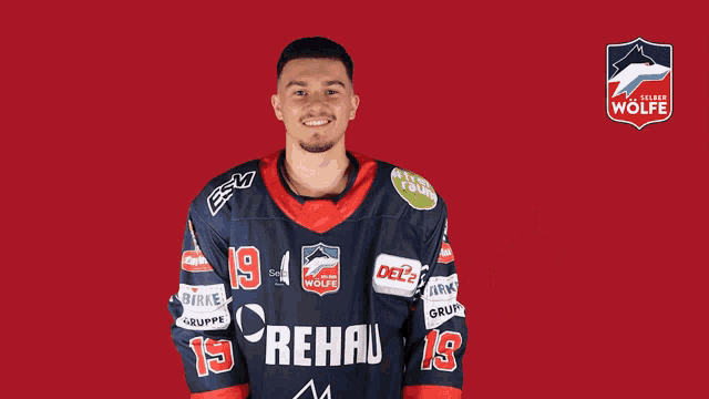a man wearing a blue and red rehau jersey