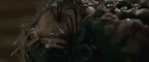 a close up of a person 's face covered in a thick , sticky substance in a dark room .