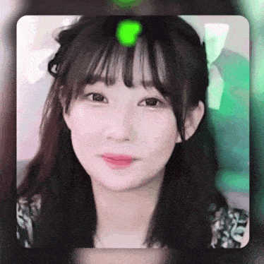 a close up of a girl 's face with a green light behind her