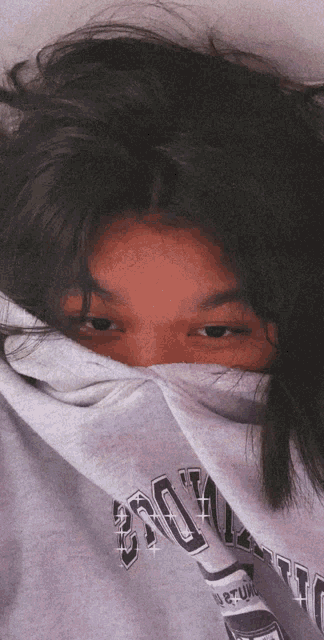 a girl covering her face with a sweater that says brooklyn