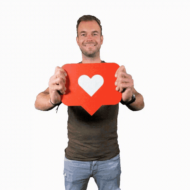 a man in a grey shirt is holding a red heart shaped icon