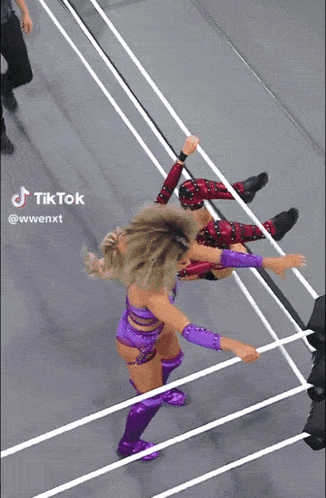 two women are wrestling in a ring with tik tok written on the bottom