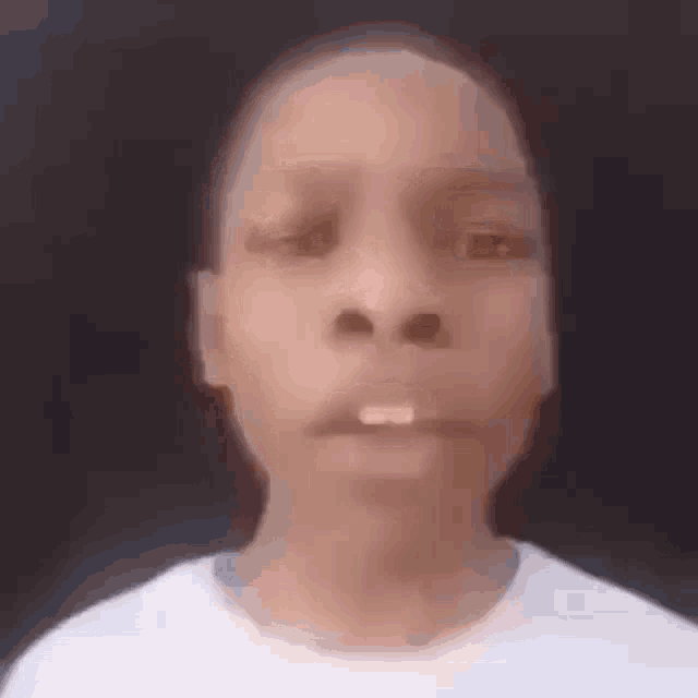 a close up of a young boy 's face with a white tooth in his mouth .