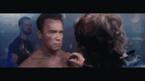 a man without a shirt is being touched by another man 's hand