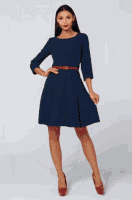 a woman in a green dress is standing on a white surface
