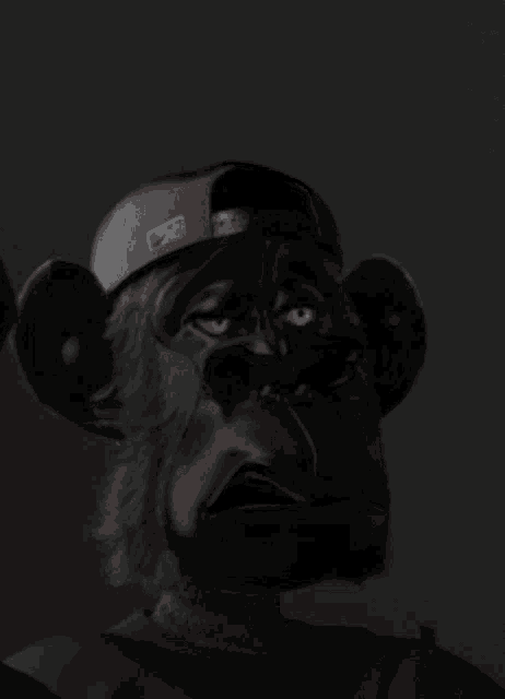a black monkey with red eyes wearing a hat with the letter l on it
