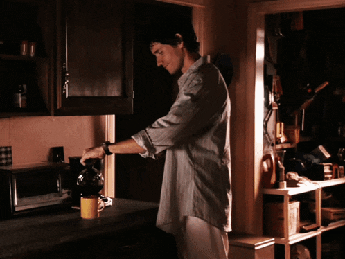 a man is pouring coffee into a yellow cup