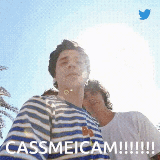 a man in a striped shirt is standing next to another man and says cassmeicam !!!