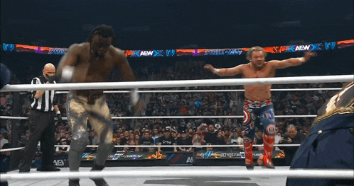 two wrestlers are in a ring with a crowd watching and a sign that says aew on it