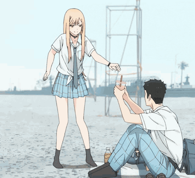 a boy and a girl are sitting on the beach and the girl is jumping in the air