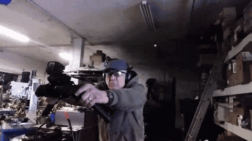 a man is holding a rifle in a dark room