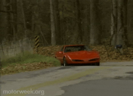 a red sports car is driving down a road with motorweek.org written on the bottom