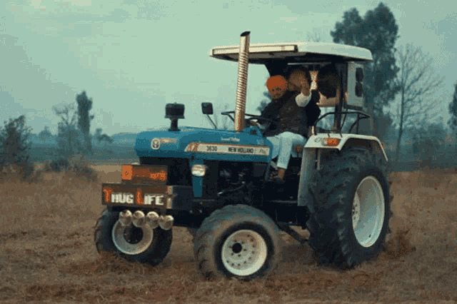 a new holland tractor with a sign that says hug life