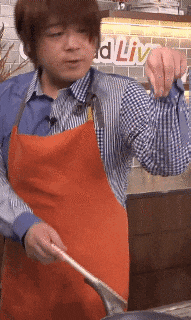 a man wearing an apron is cooking in a kitchen