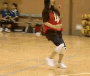 a girl in a red shirt with the number 4 on it is jumping in the air