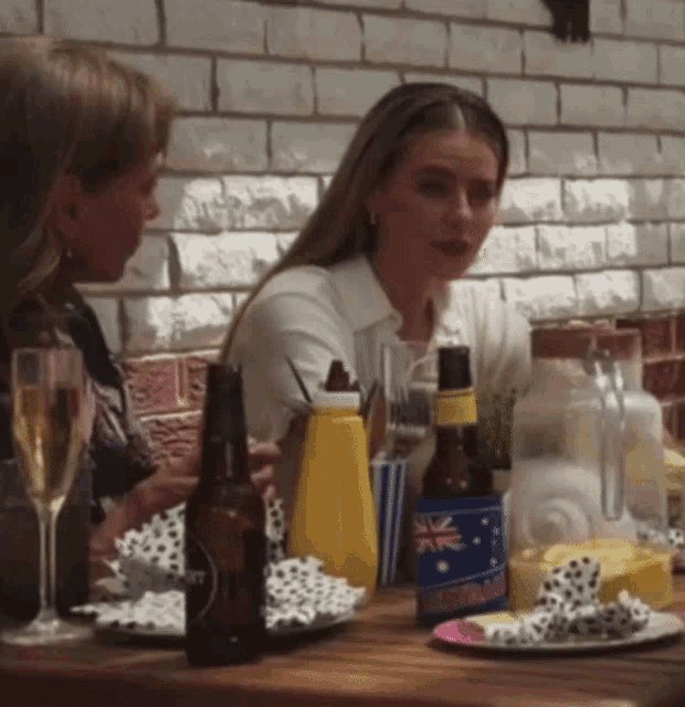 a woman sits at a table with a bottle of australia beer
