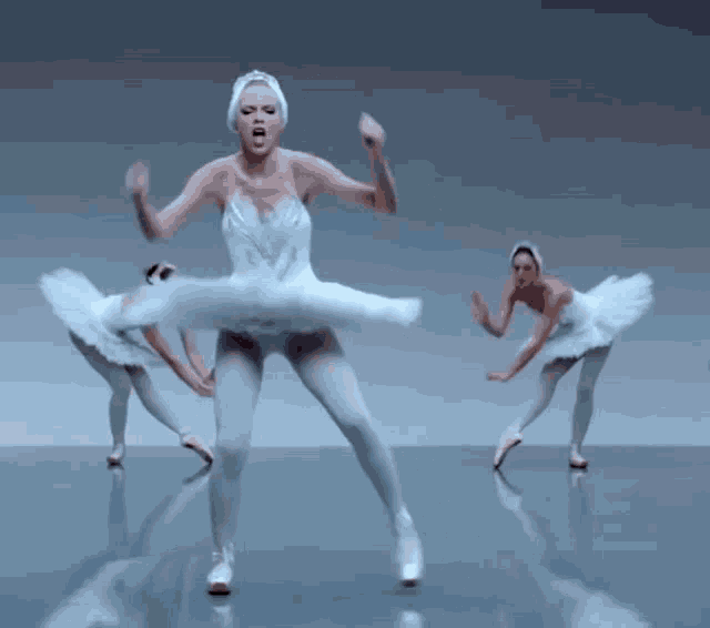 a woman in a white tutu is dancing with two other women