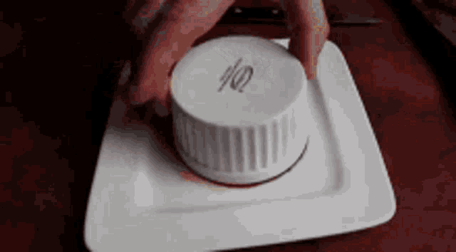 a person is pressing a button on a white plate with the number 10 on it