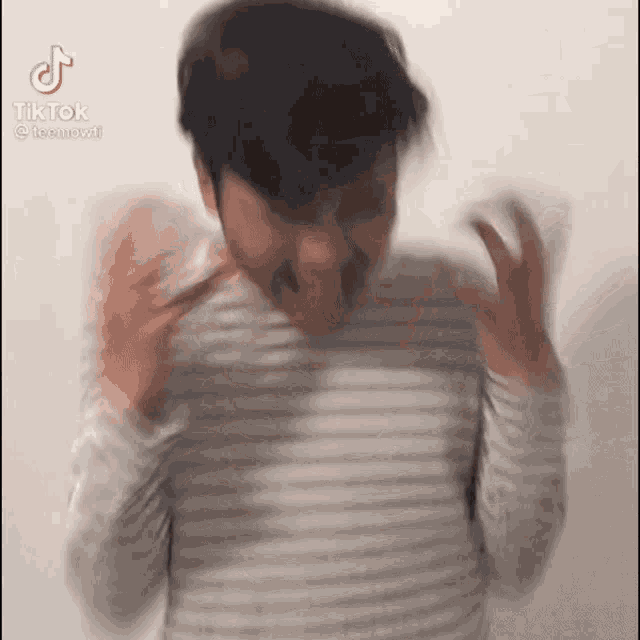 a man in a striped shirt is making a funny face in a tik tok video