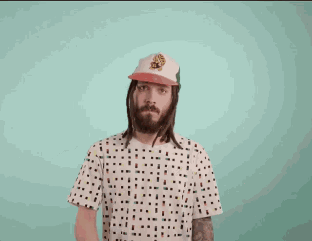 a man with dreadlocks wearing a hat with a tiger on it giving a peace sign