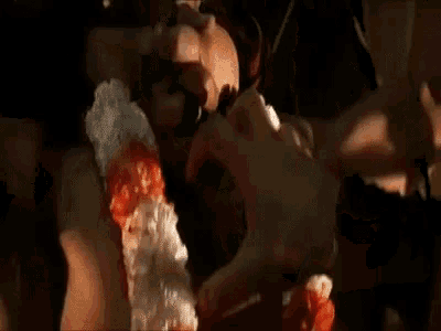 a woman is wearing a lei around her neck and a man is touching her belly .