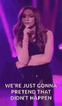 a woman is standing in front of a microphone on a stage with purple lights .