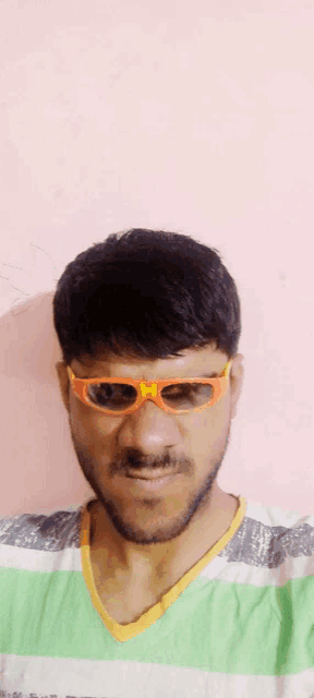 a man wearing sunglasses and a green and white shirt