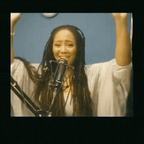 a woman wearing headphones singing into a microphone