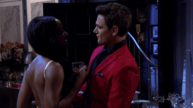 a man in a red suit stands next to a woman in a white top