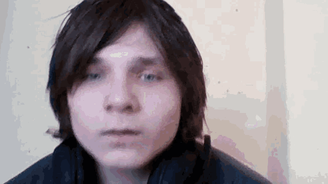a young man with long brown hair is looking at the camera