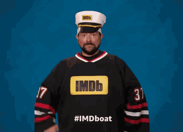 a man wearing an imdb jersey and a captain hat