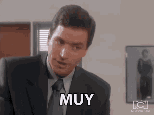 a man in a suit and tie has the word muy written on his face