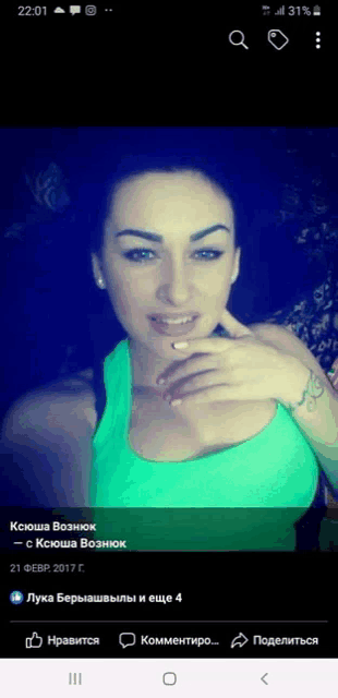a woman in a green tank top has a tattoo on her left arm