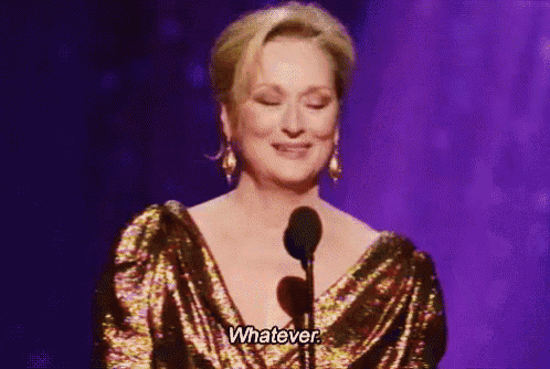 a woman in a gold dress is standing in front of a microphone and saying whatever .