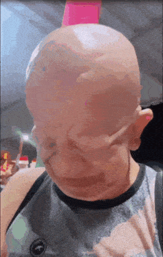 a man with a bald head and a shirt that says abercrombie & fitch on it