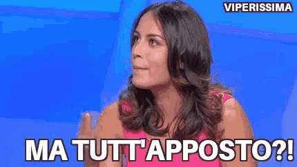 a woman in a pink dress is sitting in front of a blue background and says ma tutti apposto ?