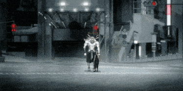 a man with spikes on his head is standing on a street with a red light behind him