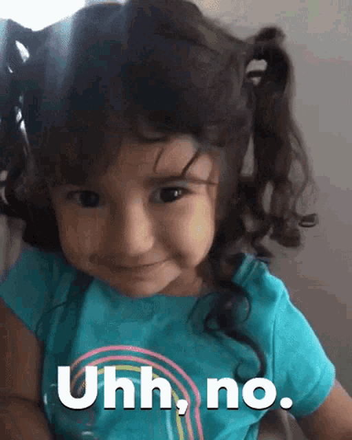 a little girl is wearing a blue shirt that says uhh no.