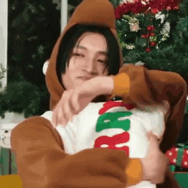 a man in a reindeer costume is holding a pillow .