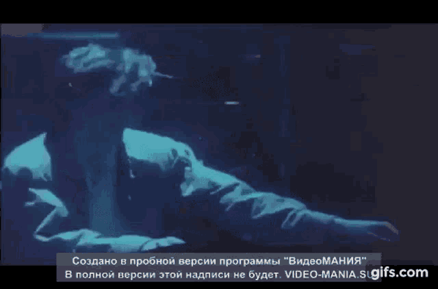 a man in a blue jacket is dancing in a dark room