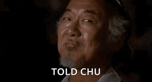 a man with a beard is smiling with the words `` told chu '' on his face .