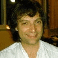 a close up of a man 's face wearing a white shirt .