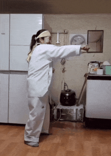 a woman in a white adidas outfit is standing in front of a refrigerator