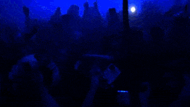 a crowd of people are taking pictures with their cell phones at a party
