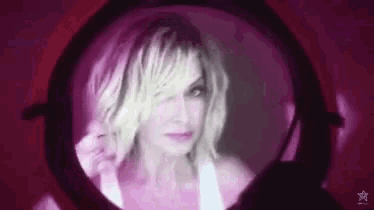 a close up of a woman 's face through a magnifying glass in a dark room .