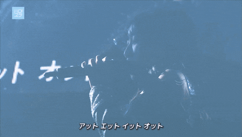a girl singing into a microphone with a blue background