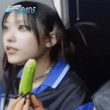 a girl is holding a green ice cream cone in her hand .